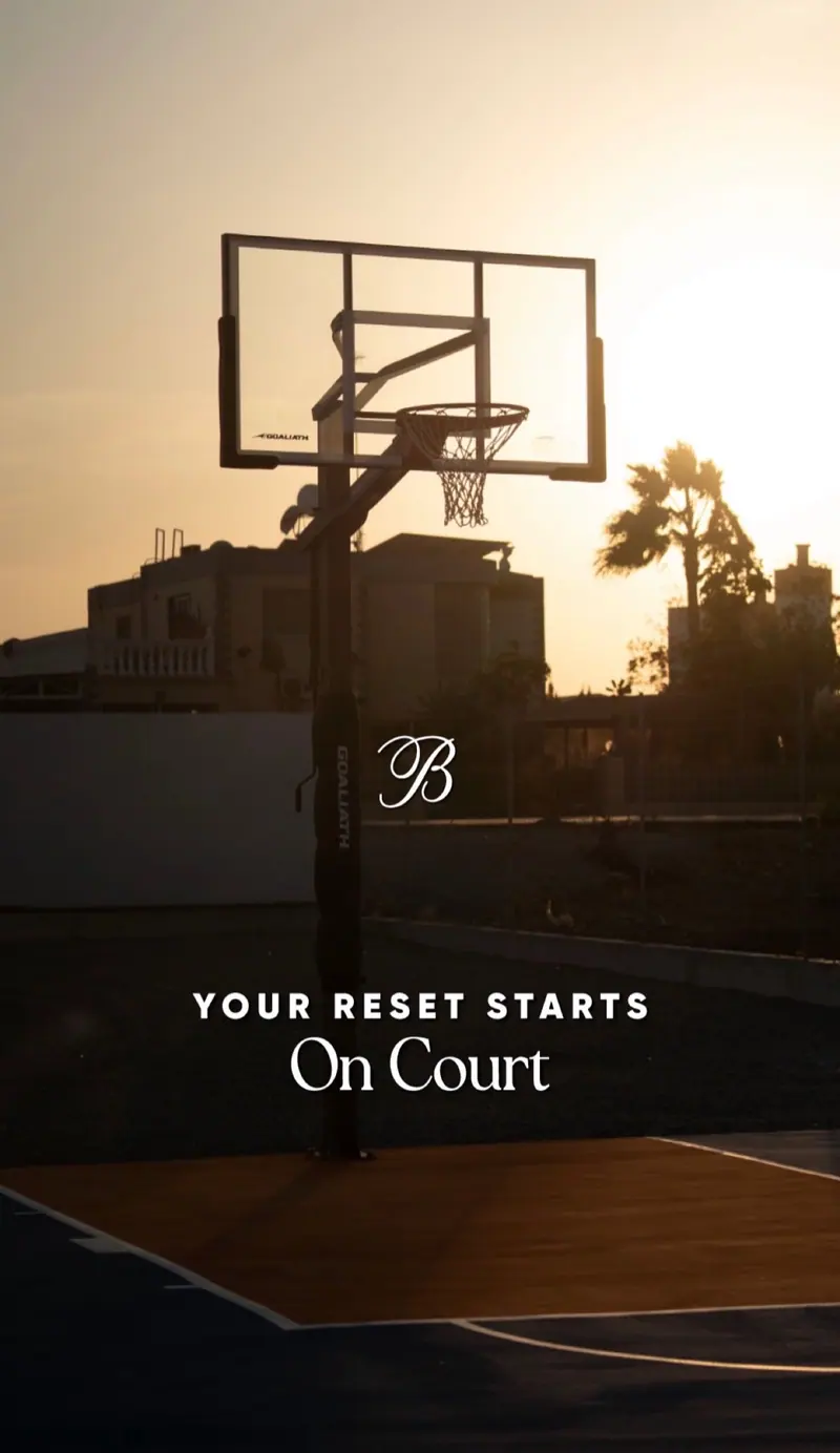 Ballers Club graphic: basketball hoop at sunset with the line “Your reset starts on court”