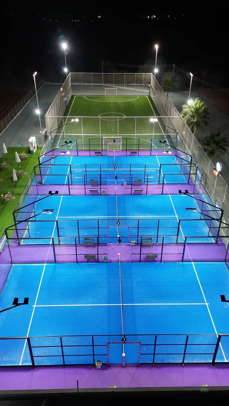 Floodlit padel courts at night from above
