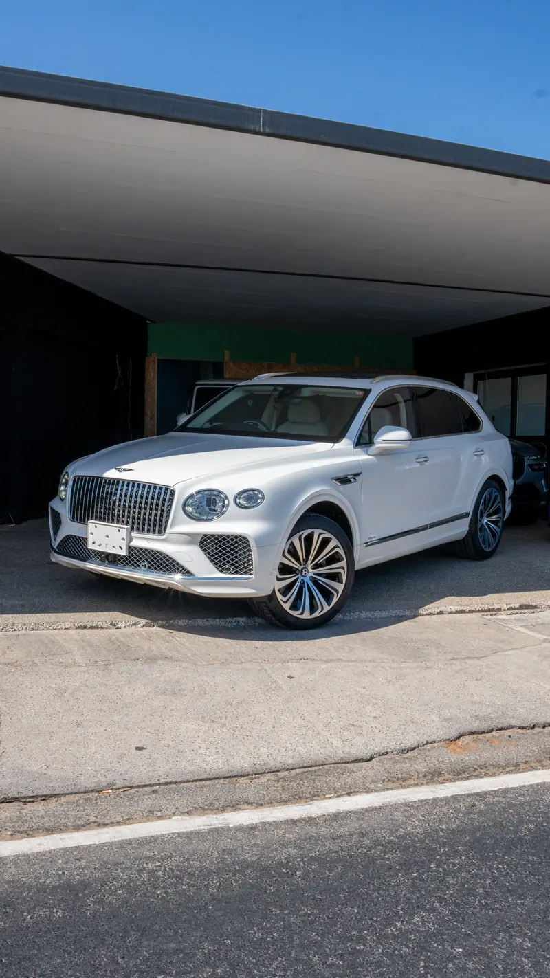 White Bentley SUV under the C&H Car Sales canopy