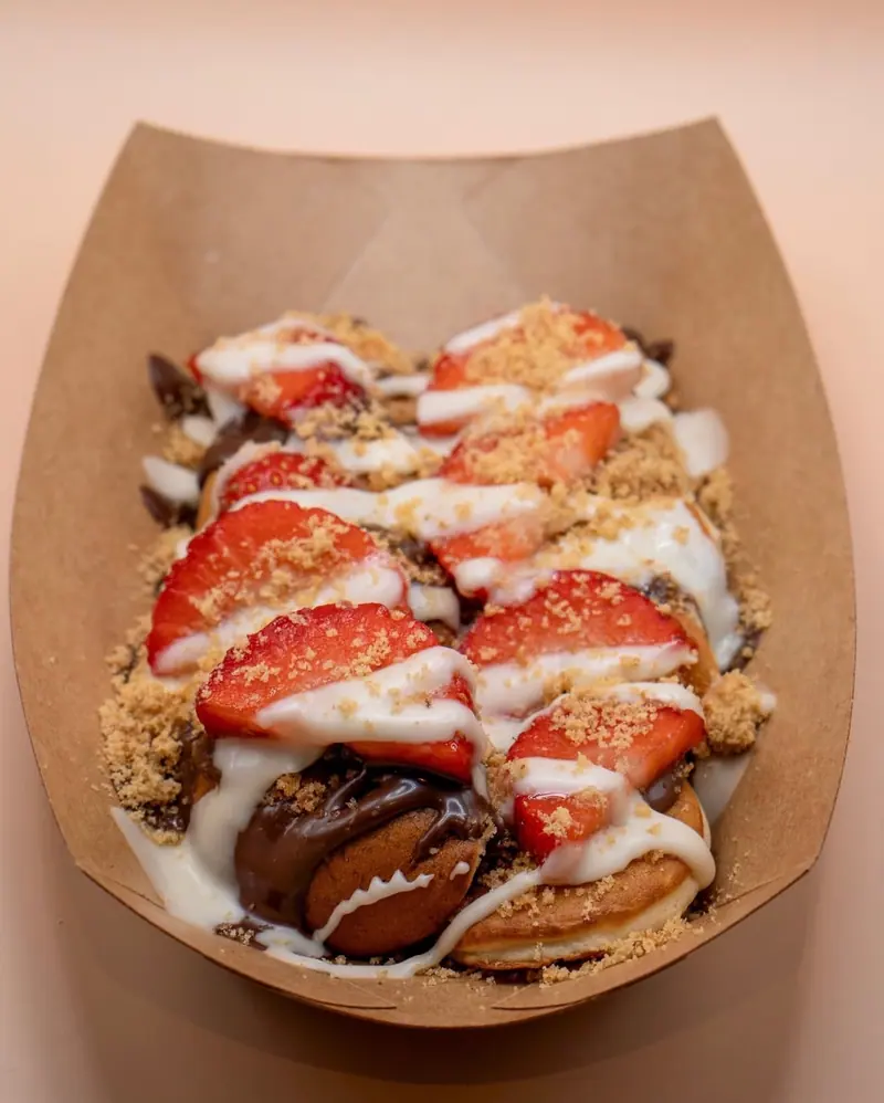 Dessert tray with strawberries, biscuit crumb and white chocolate drizzle