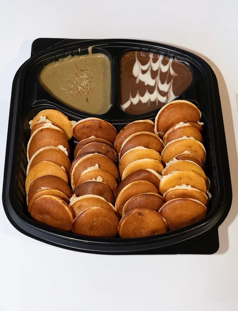 Box of mini pancakes with chocolate and pistachio dipping sauces